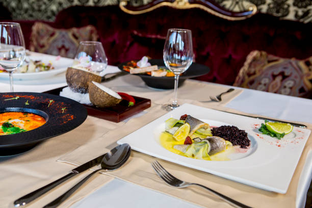 istock Served table with dishes from meat, chicken and fish with wine and whiskey. Romantic dinner in the restaurant by candlelight 811492516