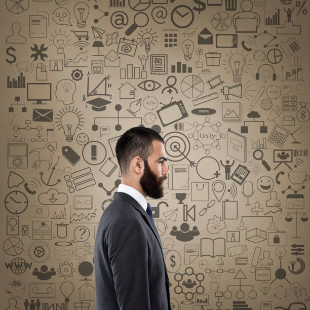 istock Businessman with icons on wall 811497516