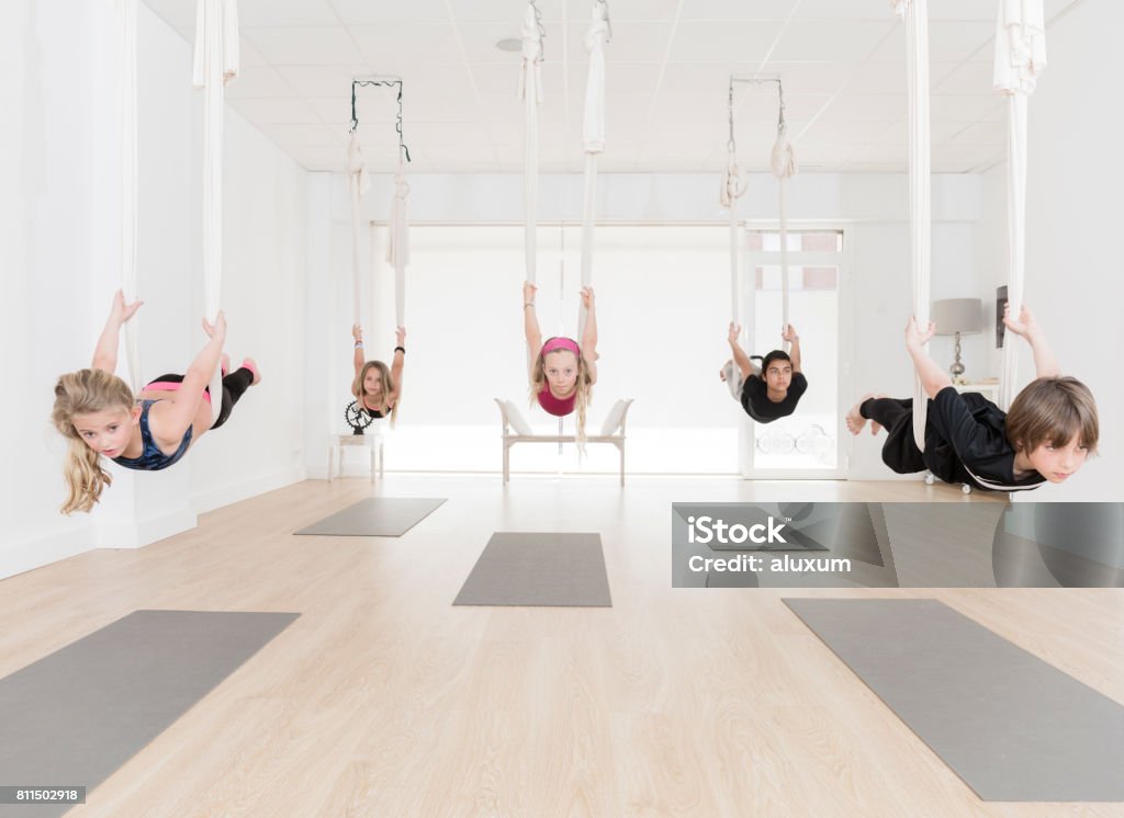 Group of children practicing aerial yoga Group of children in aerial yoga class Aerial Yoga Stock Photo