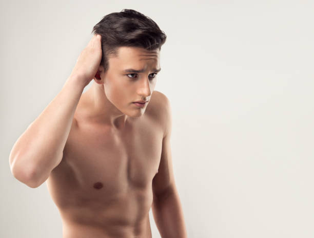 beau jeune homme torse nu est en contact avec ses cheveux. - male beauty beauty hairstyle shirtless photos et images de collection
