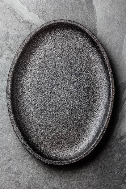 istock Food cooking background. Empty cast iron black plate on slate background 811505938