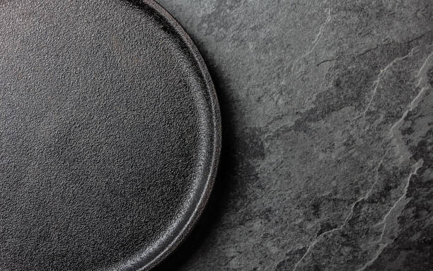 istock Food cooking background. Empty cast iron black plate on slate background 811505952