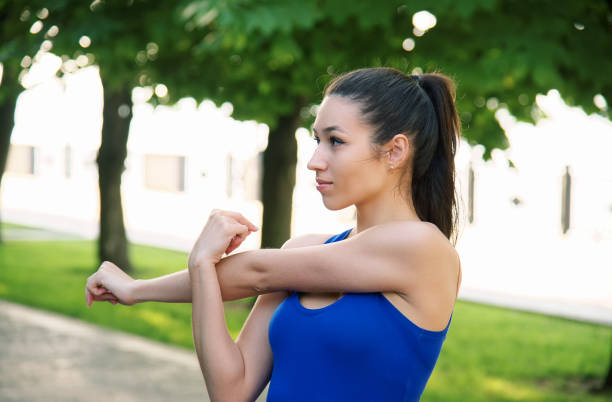 istock Young sporty woman doing shoulder exercises 811518626