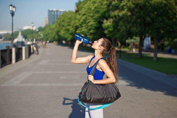 istock Young athletic woman drinks water from a bottle after a workout 811518670