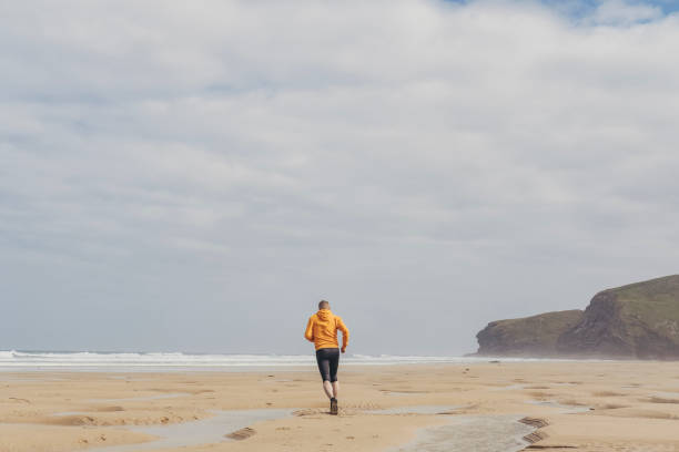 istock Man running along Watergate Bay Beach, Newquay 811518962