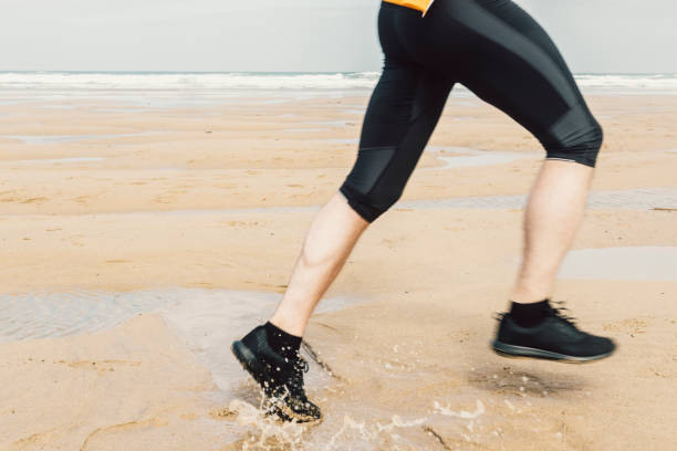 istock Blurred motion of Mans Legs running on a beach. 811519042