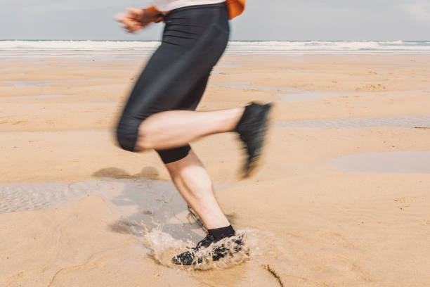 istock Blurred motion of Mans Legs running on a beach. 811519064