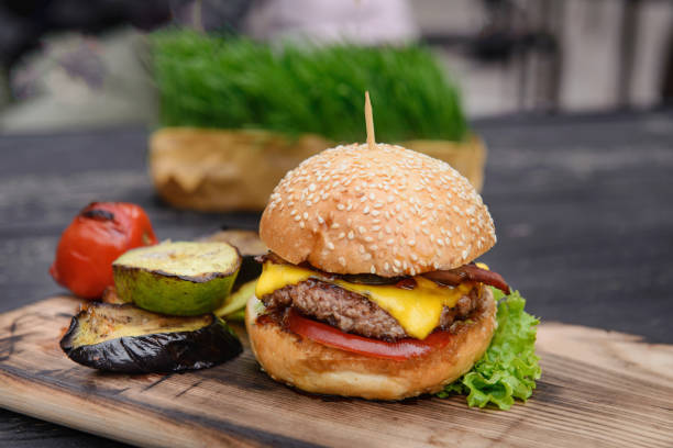 istock Cheeseburger on the wooden table with grilled vegetables 811535934