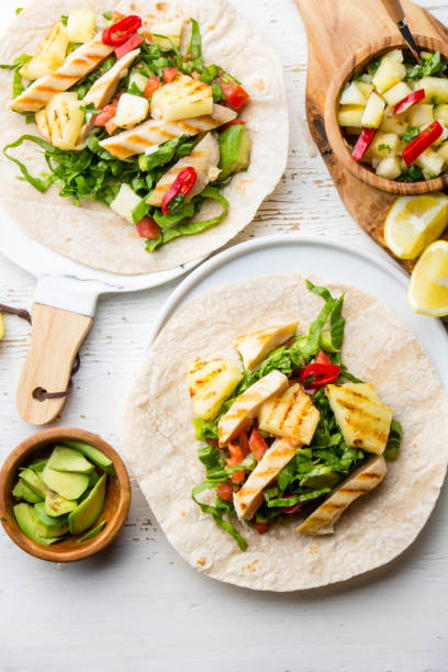 istock Mexican chicken tacos with grilled pineapple and vegetables on white background 811555056