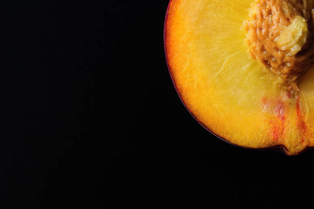 istock Peaches are whole and sliced on a black background. Empty space for text. 811555464