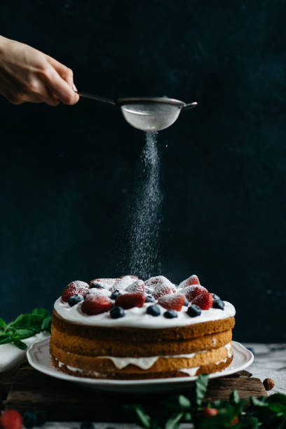 istock Woman sifting sugar powder over cake 811562898