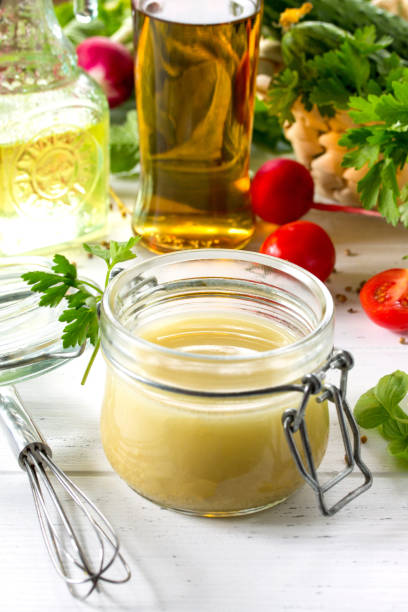 自家製のサラダ ドレッシング ドレッシング、マスタードとオリーブ オイルで白いキッチン木製テーブルの上。 - vinegar bottle herb white ストックフォトと画像