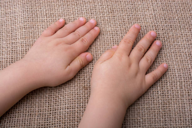 View of father and son's hands together.