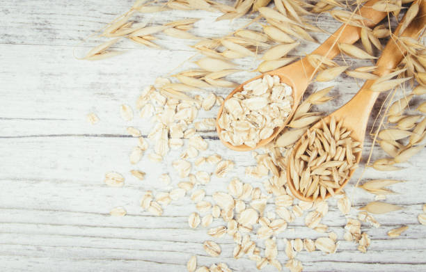 istock Raw oat flakes on a wooden table - closeup. 811579922