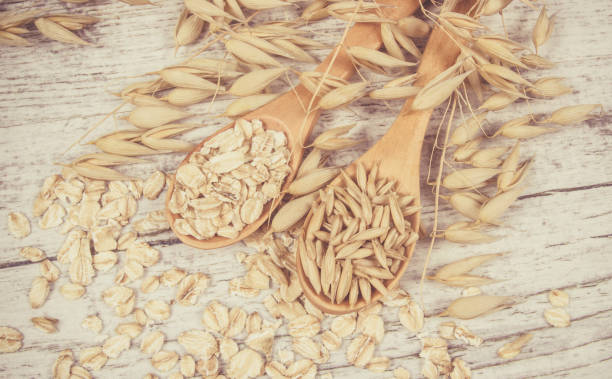 istock Raw oat flakes on a wooden table - closeup. 811584568