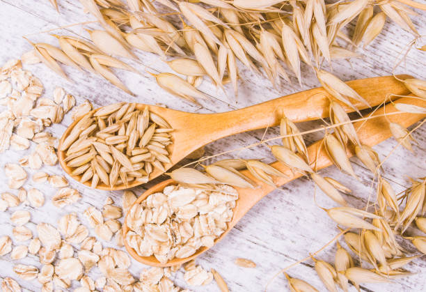 istock Raw oat flakes on a wooden table - closeup. 811605346