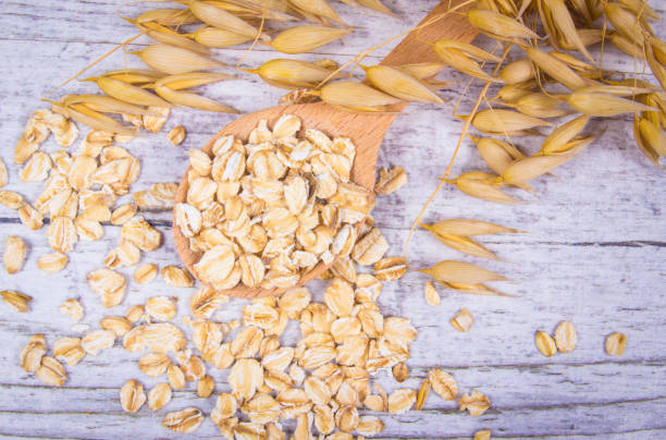 istock Raw oat flakes on a wooden table - closeup. 811605914