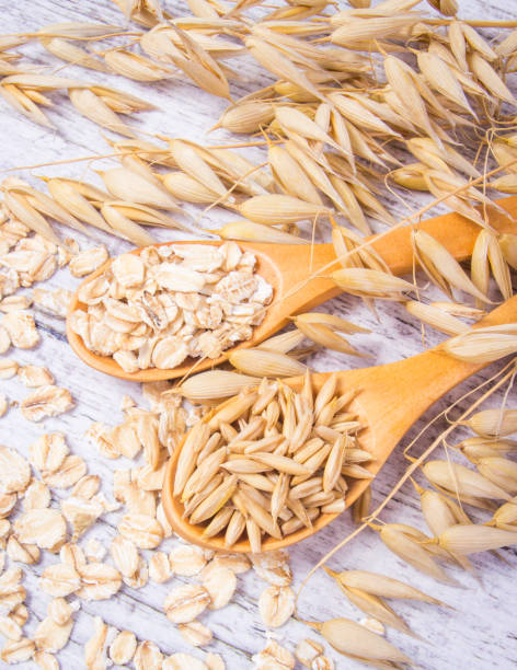 istock Raw oat flakes on a wooden table - closeup. 811614978