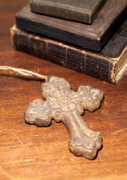 Cross with antique books on a wooden desk stock photo