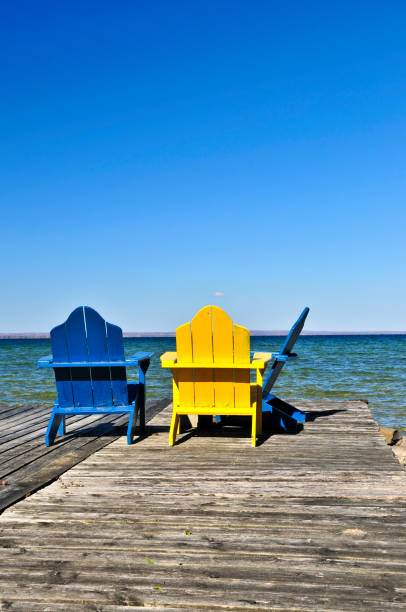 istock Chairs on wooden dock at lake 811663334