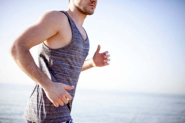 istock Young man running at the beach 811665804