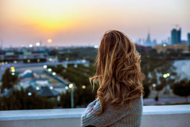 istock Woman looking at the sunset 811665908