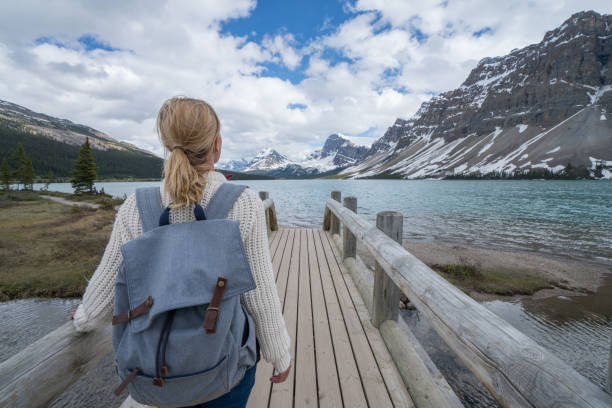 istock Young woman by the mountain lake 811672588