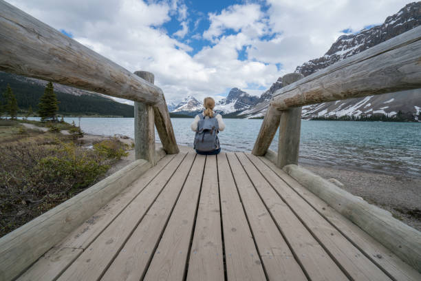 istock Young woman by the mountain lake 811679576