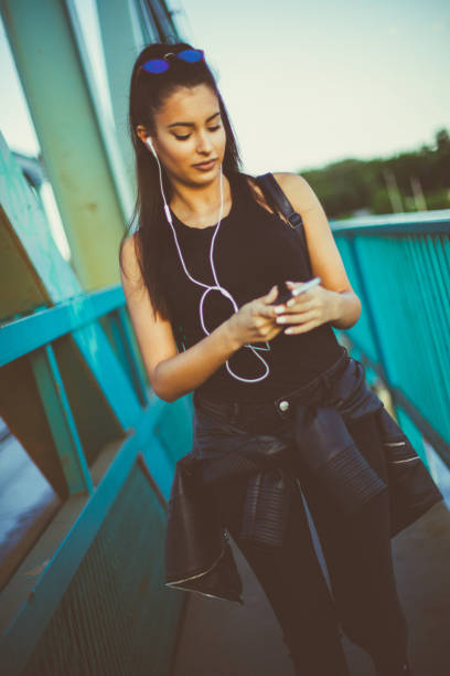 hermosa chica caminando y escuchando música en el puente - grand river audio fotografías e imágenes de stock
