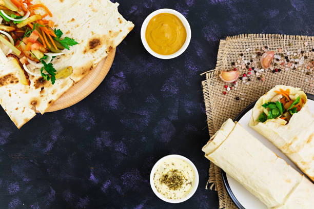istock Shawarma sandwich with ingredients on dark background. Top view 811682294