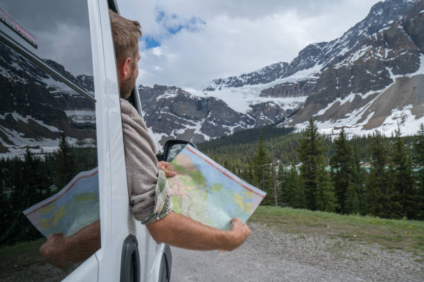 istock Passenger's car looking at road map in mountain landscape 811699738
