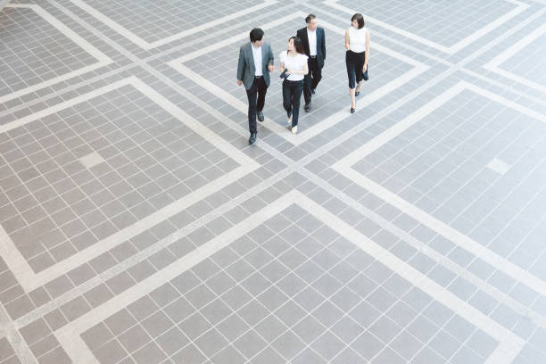 Business people walking through Japanese office foyer, overhead view stock photo