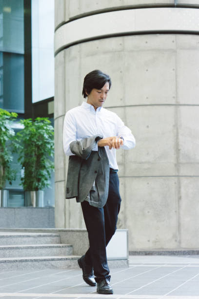 istock Business man checking time and walking through building 811711918