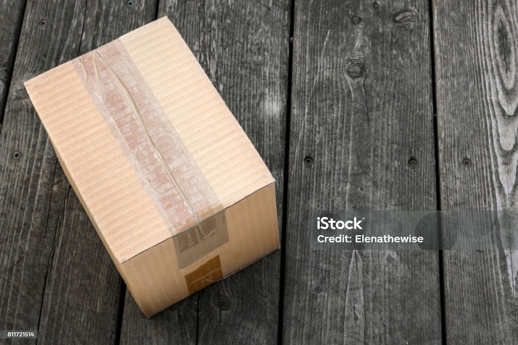Delivery box Cardboard delivery parcel box delivered to doorstep on old wood background Box - Container Stock Photo