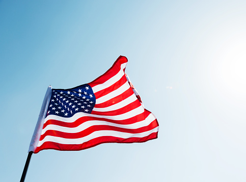 American flag waving against blue sky