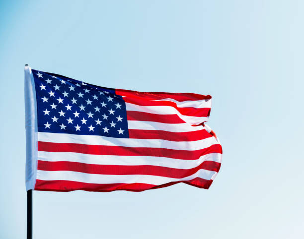 istock American flag waving against blue sky 811728296