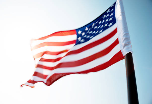 istock American flag waving against blue sky 811728406