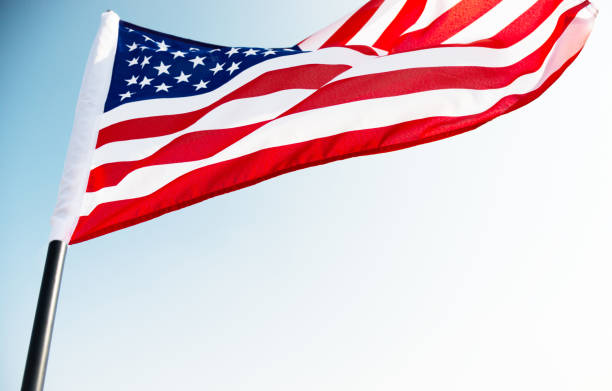 istock American flag waving against blue sky 811728448