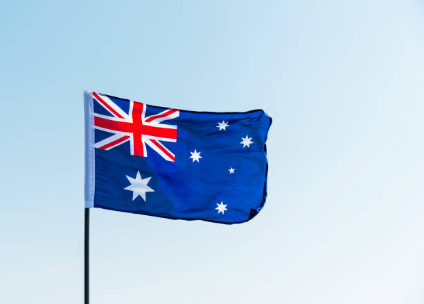 istock Waving Australia flag against blue sky 811730890