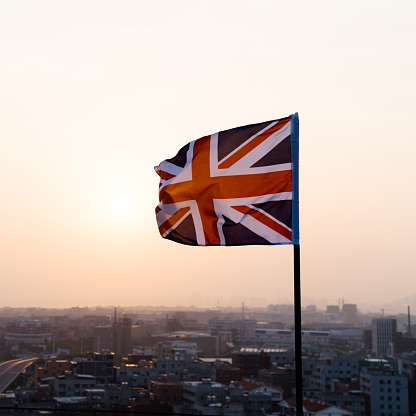 Flag of the United Kingdom waving in sunset