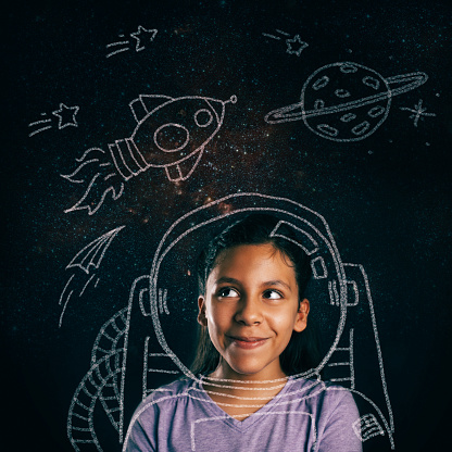 Young girl smiling, imagining she will be an astronaut.