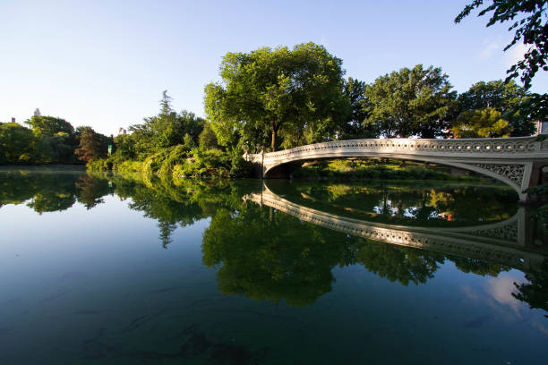 istock Bow bridge clearly reflects on the lake at Central Park with sky 811745426