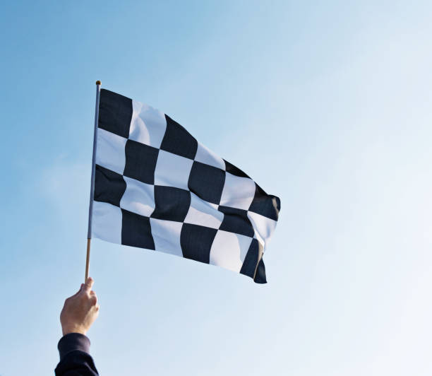 istock Man hand holding checkered flag in the wind 811755254