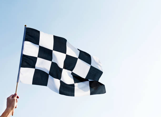 istock Man hand holding checkered flag in the wind 811755258