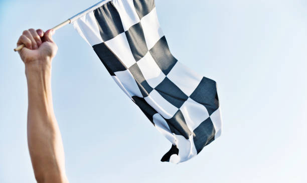 istock Man hand holding checkered flag in the wind 811755278