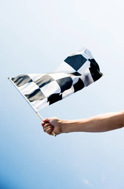 istock Man hand holding checkered flag in the wind 811755284
