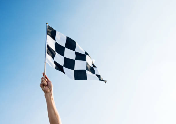 istock Man hand holding checkered flag in the wind 811755288