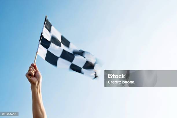 Man Hand Holding Checkered Flag In The Wind Stock Photo - Download Image Now - Finish Line, Starting Line, Beginnings