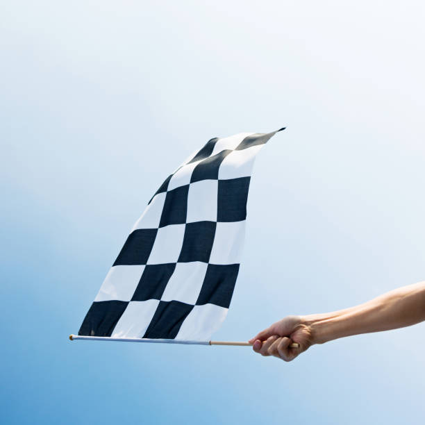 mano del hombre con la bandera a cuadros en el viento - checkered flag flag auto racing starting line fotografías e imágenes de stock