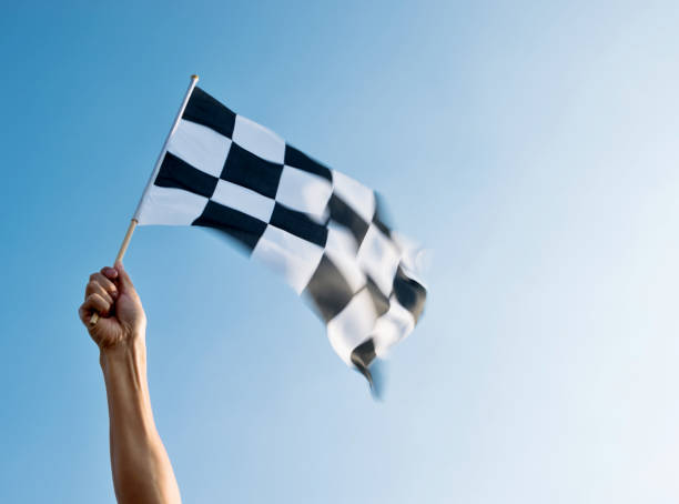 istock Man hand holding checkered flag in the wind 811755324